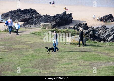 Newquay,Cornwall,18. Oktober 2020,Menschen gehen mit Hund spazieren und genießen das warme Wetter an einem schönen sonnigen Tag in Fistral Beach, Cornwall. Der Strand ist berühmt, da Leute aus dem ganzen Land reisen, um die berühmte Brandung zu reiten.Quelle: Keith Larby/Alamy Live News Stockfoto