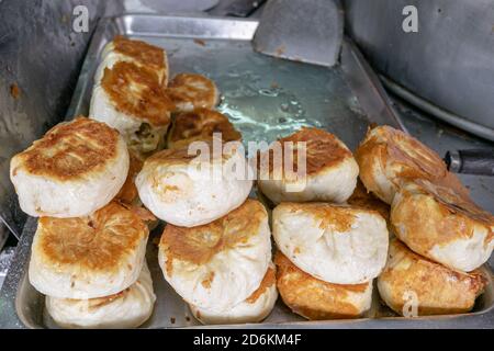 Nahaufnahme von taiwanesischen Schweinebraten (Sheng Jian Bao) auf dem Lebensmittelmarkt in Kaohsiung, Taiwan. Stockfoto