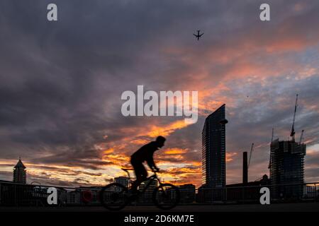 Ein Radfahrer mit Silhouette vor dem Hintergrund des Lots Road Kraftwerks, Chelsea Harbour und Stockfoto