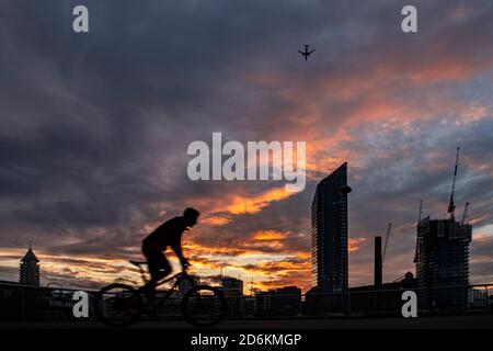 Ein Radfahrer mit Silhouette vor dem Hintergrund des Lots Road Kraftwerks, Chelsea Harbour und Stockfoto