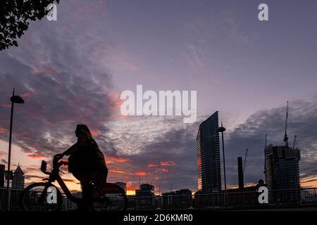 Ein Radfahrer mit Silhouette vor dem Hintergrund des Lots Road Kraftwerks, Chelsea Harbour und Stockfoto