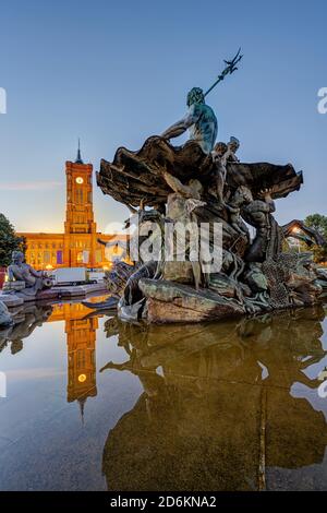 Der Neptunbrunnen am Alexanderplatz in Berlin im Morgengrauen Mit dem Rathaus im Hintergrund Stockfoto