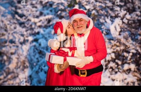 Lieber weihnachtsmann. Santa Helfer mit Geschenke im Freien. Schöne verschneite Winter. Kind und älterer Mann bereit, Urlaub zu feiern. Winterurlaub und Urlaub. Opa in santa Kostüm mit kleinen Mädchen. Stockfoto