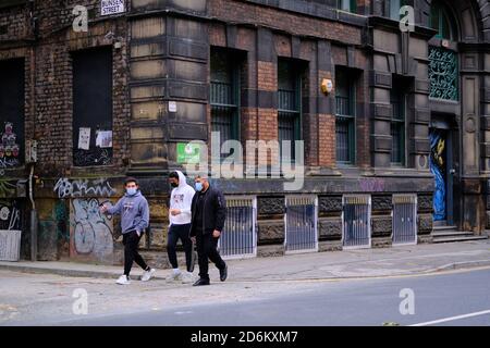 Manchester / Vereinigtes Königreich - 17. Oktober 2020: Drei junge Männer mit Gesichtsmasken in der Manchesters Street. Stockfoto