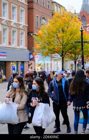 Manchester / Großbritannien - 17. Oktober 2020: Manchester Einkaufsstraße während Pandemie. Junge zwei Frauen tragen Gesichtsmasken und halten die Ladentin