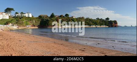 Roundham Head vom Goodrington Beach aus gesehen. Ganz rechts befindet sich das Kreuzfahrtschiff Zaandam, das während der Coronavirus-Pandemie in Torbay vor Anker liegt. Stockfoto