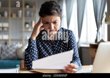 Indische Ethnizität Frau sitzen am Schreibtisch Lesen Brief fühlt sich enttäuscht Stockfoto