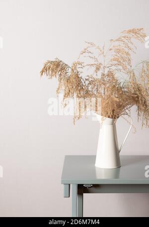 Pampas Gras in Vase auf einem Couchtisch gegen eine graue Wand. Stockfoto