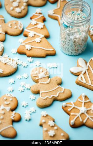 Happy New Year's Set von Lebkuchen und Mann in Gesicht Maske aus Ingwer Kekse glasierten Zucker Glasur Dekoration auf blauem Hintergrund, minimale Saison Stockfoto