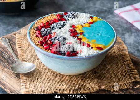 Blaue Spirulina Smoothie Schale mit Obst und Leinsamen - gesunde Superfood Frühstücksidee. Stockfoto