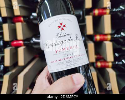 Builboreau, Frankreich - 14. Oktober 2020:Nahaufnahme von man Hand beim Kauf einer Pomerol klassifizierten Wachstumsflasche, einem großen französischen bordeaux-Wein im Supermarkt Stockfoto