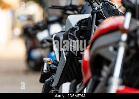 Eine Reihe von Motorrädern auf der Seite der Straße geparkt, Nahaufnahme von Details, Weichfokus, städtischen Hintergrund Stockfoto