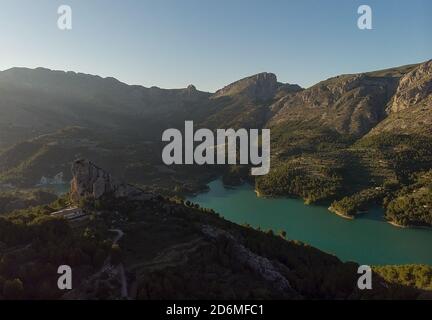 Luftaufnahmen Guadalest Reservoir türkisfarbenes Wasser und umgebene Berge während des sonnigen Morgens. Valencianische Stadt. Spanien Stockfoto