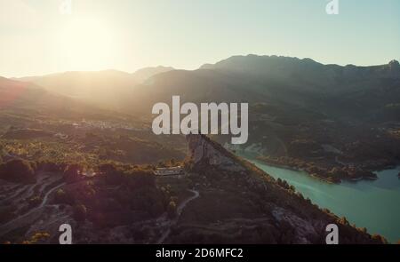 Luftaufnahmen Guadalest Reservoir türkisfarbenes Wasser und umgebene Berge während des sonnigen Morgens. Valencianische Stadt. Spanien Stockfoto