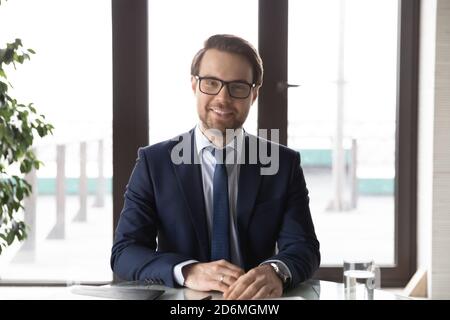 Portrait von glücklichen jungen selbstbewussten männlichen Führer, sitzen am Tisch. Stockfoto