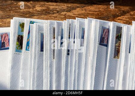 Briefe in gestempelten Umschlägen, für die Big Send-Initiative von Vote Forward, werden auf einem Holztisch ausgefächelt Stockfoto