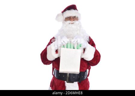 Älterer Mann trägt ein traditionelles Sant Claus Kostüm und hält eine Geschenktüte in beiden Händen. Isoliert auf Weiß. Stockfoto