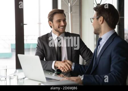 Lächelnd zwei junge Geschäftsmann schüttelt die Hände, Vereinbarung. Stockfoto