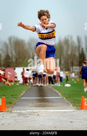 Weibliche konkurriert in der Weitsprung Veranstaltung an einem Gymnasium Track meet Stockfoto