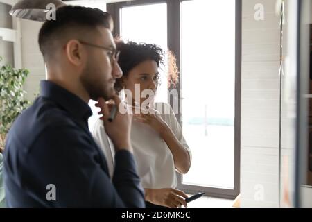 Fokussierte junge multirassische Mitarbeiter denken an schwierige Problemlösung. Stockfoto