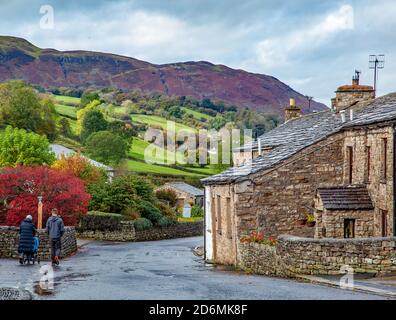 Person, die durch die gepflasterten Straßen des Dorfes Cumbrian aufwacht Von Dent in Dentdale im Yorkshire Dales Nationalpark Cumbria England Großbritannien Stockfoto