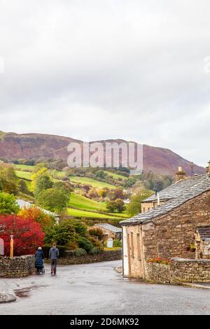 Person, die durch die gepflasterten Straßen des Dorfes Cumbrian aufwacht Von Dent in Dentdale im Yorkshire Dales Nationalpark Cumbria England Großbritannien Stockfoto