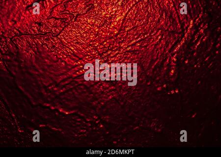 Beleuchtet in rot schwarz Textur Wand als Hintergrund Stockfoto