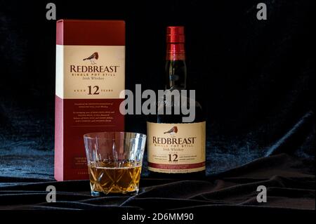 Stillleben von Redbreast irish Whiskey Flasche und Crsytal Whisky Becher auf schwarzem Samthintergrund Stockfoto
