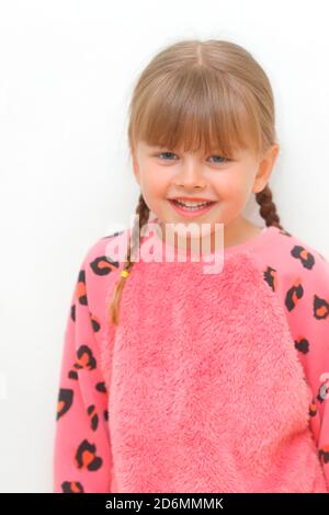 Ein glückliches 5-jähriges Mädchen mit Zöpfen. Stockfoto