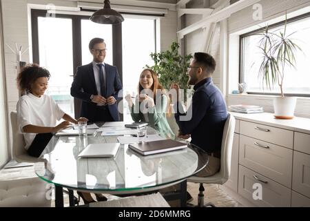 Glückliche junge, vielfältige Geschäftsleute, die eine entspannte Atmosphäre im Büro genießen. Stockfoto