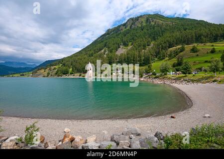 Reschensee mit seinem berühmten halb-untergetauchten Glockenturm von Curon, Vinschgau, Bozen, Trentino-Südtirol, Italien Stockfoto