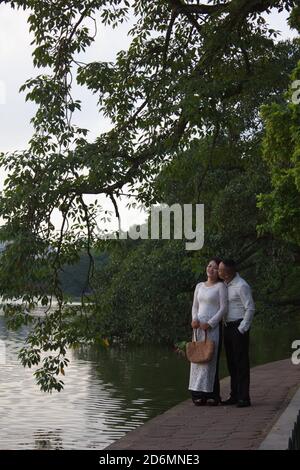 Ein vietnamesisches Paar posiert für Pre-Hochzeit Fotos am Hoan Kiem See in Hanoi, Vietnam Stockfoto