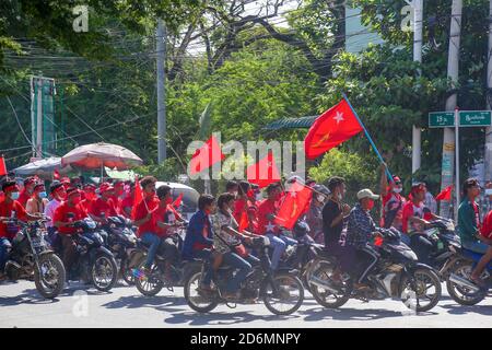 Motorradfahrer fahren während der Kampagne mit Partyflaggen. Befürworter der Kampagne der Nationalen Liga für Demokratie in Mandalay mit einer großen Anzahl von Menschen, darunter 100 Kranwagen Teil des Wahlkampfs. Stockfoto