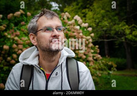 Porträt eines reifen Mannes in Brillen und einem Sport Pullover im Freien im Park Stockfoto