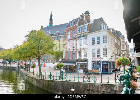 Hohe traditionelle Häuser in der historischen Stadt Leiden. Der Markt wird seit Jahrhunderten auf der Kanalstraße abgehalten. Im Hintergrund das Rathaus. Stockfoto