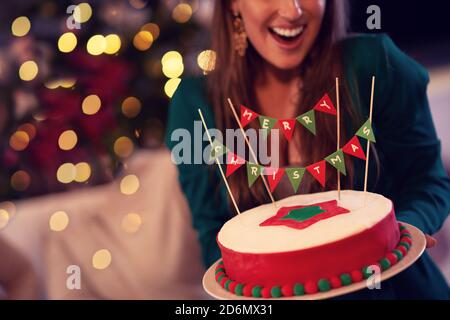 Mittelteil der Frau hält Weihnachtskuchen Stockfoto