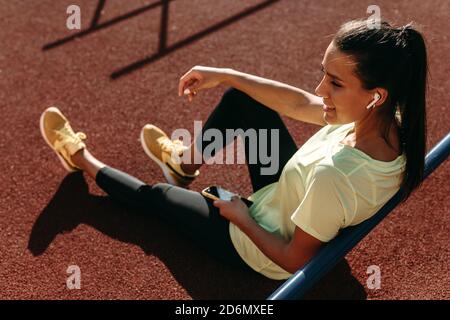 Sportliche Frau, die nach dem Training Musik auf dem Smartphone hört Stockfoto