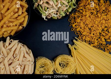 Auswahl von verschiedenen Arten von Pasta trocken auf schwarzem Hintergrund. Stockfoto