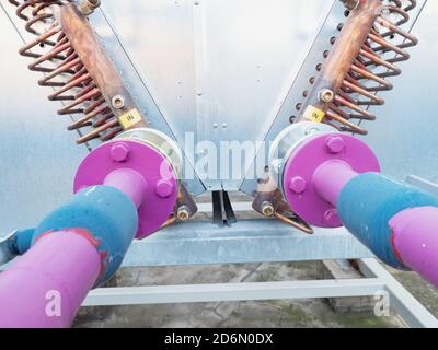 Industrielle Kühleinheit auf Biomasse-Kraftwerk. Pinke und blaue Rohre, Flansche und Ventile. Ventilator im Industriegebäude. Alternative Energieproc Stockfoto