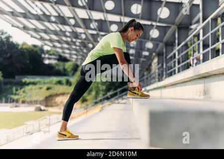 Schöne Frau binden Schnürsenkel an Turnschuhen vor dem Training Stockfoto