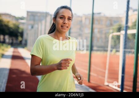 Selbstbewusstes sportliches Laufen im Stadion am Morgen Stockfoto