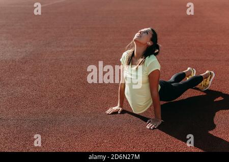 Flexible junge Frau Stretching Körper im Freien Stockfoto