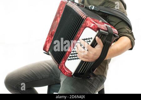 Nahaufnahme eines Mannes in einem schwarzen Hemd, der die rote Ziehharmonika-Hand aus der Nähe spielt Stockfoto