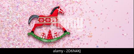 Weihnachtsbaum Holzspielzeug von Schaukelpferd auf rosa Hintergrund mit Glitzer. Flach liegend, Draufsicht von mit Kopierplatz Stockfoto