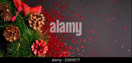 Weihnachtskranz mit rotem Glitzer auf schwarzem Hintergrund, flach liegend mit Kopierfläche Stockfoto