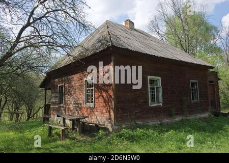 Ein verlassenes Holzhaus im Wald. Ein altes Holzhaus. Konstruktion mit Schieferdach. Stockfoto