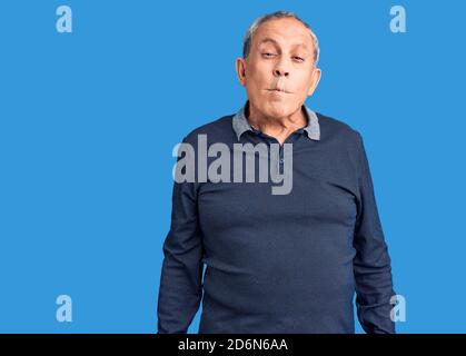 Senior schöner Mann trägt Casual Polo machen Fisch Gesicht mit Lippen, verrückt und komisch Geste. Lustiger Ausdruck. Stockfoto