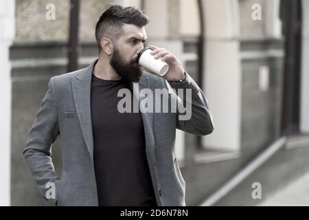 Entspannen und erholen Sie sich. Man bärtige hipster Pappbecher Kaffee trinken. Noch ein Schluck Kaffee. Kaffee trinken für Unterwegs. Geschäftsmann lumbersexual Erscheinungsbild genießen Sie Kaffee Pause aus Business Center. Stockfoto