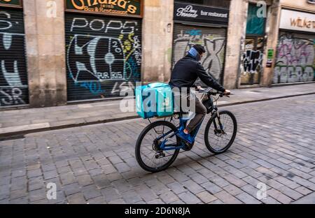 Ein Deliveroo-Bote ist auf der Calle Ferrán in der Nähe der Plaza Sant Jaume im Umlauf, Um Hauslieferungen zu machen.die Aktivität rund um Essen zum Mitnehmen hat in Barcelona aufgrund der Verordnung der katalanischen Regierung, die kommerzielle Tätigkeit von Bars und Restaurants für 15 Tage wegen der Zunahme der Ansteckung von Covid19 zu schließen, zugenommen. Stockfoto