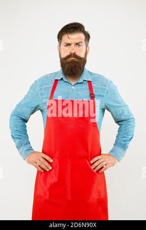 Bärtiger Mann in Koch Uniform. Reifer Verkäufer. Koch in roter Schürze. Restaurantpersonal. Hobby Kochen. Viele Liefertage Optionen. Die ganze Familie würde es genießen. Kochen zu Hause. Hilfe im Haus. Stockfoto
